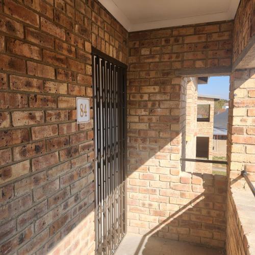 a brick wall with a gate on it at Two Bedroom townhouse THE PINES ALBERTSDAL in Alberton