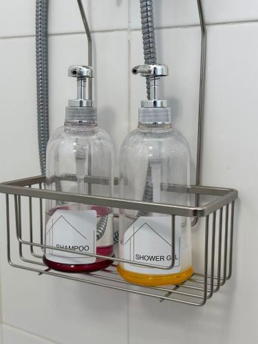 a shelf with two soap bottles in a bathroom at Guest House MJ in Póvoa de Varzim