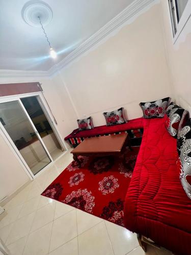- un canapé rouge dans le salon avec une table dans l'établissement مغوغة كبيرة طريق تطوان, à Tanger