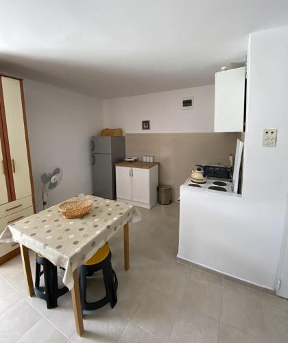 a kitchen with a table and a small kitchen with a refrigerator at Apartman Copacabana in Krašići
