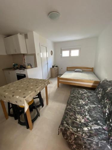 a small room with a table and a kitchen at Apartman Copacabana in Krašići