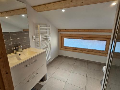 une salle de bain avec un lavabo et une fenêtre dans l'établissement Cozy, quiet apartment in town center - near Geneva, Annecy, Chamonix, Lac Léman, à Bons