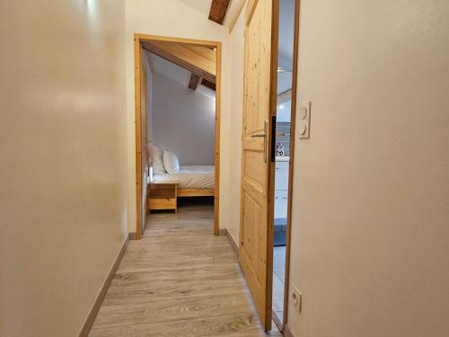 un couloir menant à une chambre avec un lit dans l'établissement Cozy, quiet apartment in town center - near Geneva, Annecy, Chamonix, Lac Léman, à Bons