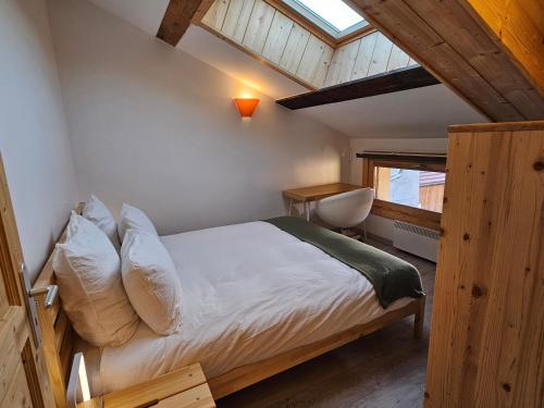 um quarto com uma cama com lençóis brancos e uma janela em Cozy, quiet apartment in town center - near Geneva, Annecy, Chamonix, Lac Léman em Bons