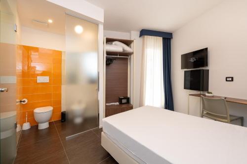 um quarto de hotel com uma cama e um WC em Hotel Velia em Grottammare
