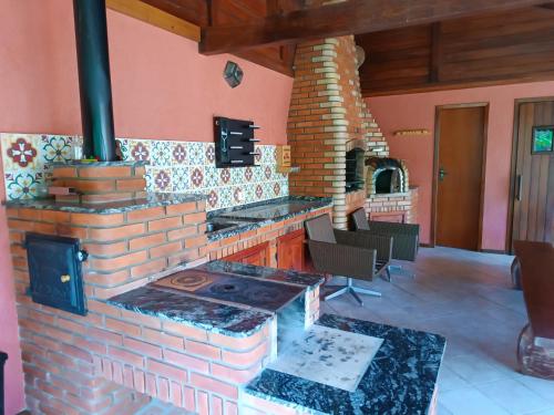 een keuken met een bakstenen kachel in een kamer bij Refúgio Allamanda in Visconde De Maua