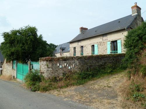 une ancienne maison en briques avec des portes vertes et un mur dans l'établissement L' ALBIZIA, à Saint-Martin-de-Sallen