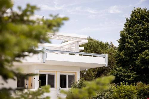 a white house with trees in front of it at Zeusplace PoolVilla Natura Paralia Katerini in Katerini