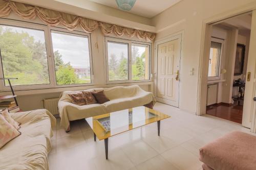 a living room with a couch and a table at Zeusplace PoolVilla Natura Paralia Katerini in Katerini