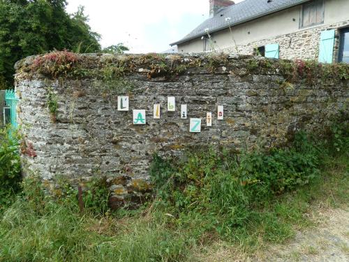 un mur en briques avec des panneaux. dans l'établissement L' ALBIZIA, à Saint-Martin-de-Sallen