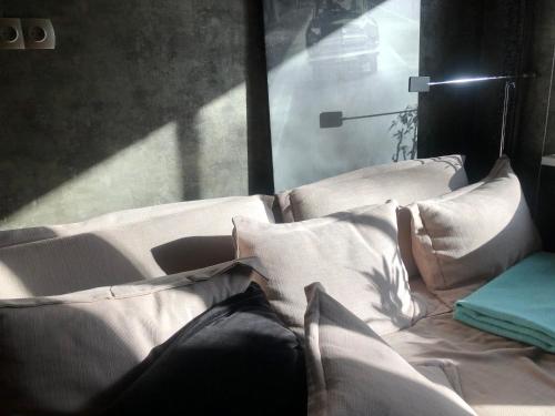 - un lit avec des oreillers blancs assis à côté d'une fenêtre dans l'établissement Olga apartment, à Riga