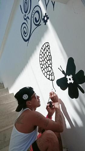 two women are looking up at a wall with butterflies on it at Shoffi's House Backpackers in Tarapoto