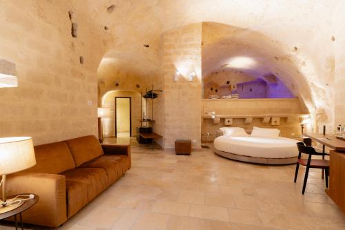 a bedroom with a bed and a couch in a room at BV Quarry Matera in Matera