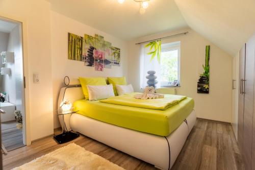 a bedroom with a yellow and white bed in a room at Leeloo s Sunlight in Hodenhagen