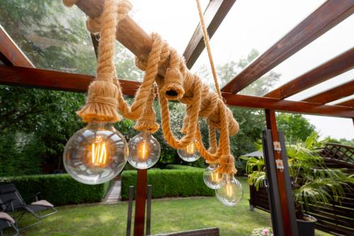a rope chandelier with lights hanging from a roof at Leeloo s Sunlight in Hodenhagen