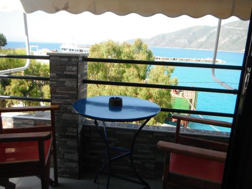 a table on a balcony with a view of the ocean at Orfeas Rooms in Vasiliki