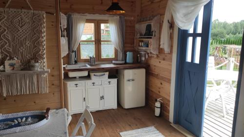 a kitchen in a log cabin with a refrigerator at Skotopaska & Bukolika in Idzbark