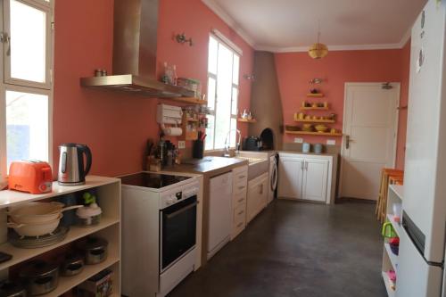 een grote keuken met oranje muren en witte kasten bij Villa aloe vera in Essaouira