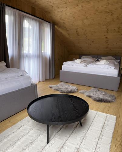 a room with two beds and a table in it at CHALET COBURG in Telgárt