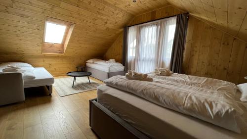 a bedroom with two beds in a wooden cabin at CHALET COBURG in Telgárt