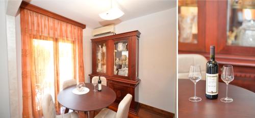 ein Esszimmer mit einem Tisch und einer Flasche Wein in der Unterkunft Apartment Nikolija in Dobrota