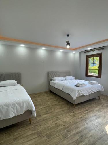 a bedroom with two beds and a window at Kaya Palace in Uzungöl