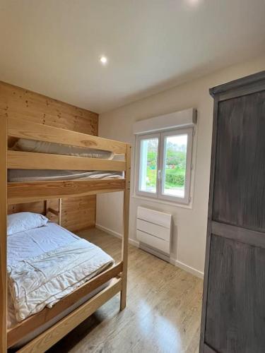 1 dormitorio con 2 literas y ventana en Chalet à proximité du lac villefranche de panat, en Lestrade-et-Thouels