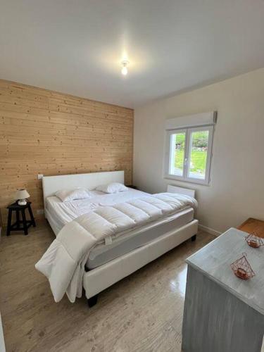 Un dormitorio con una cama grande y una ventana en Chalet à proximité du lac villefranche de panat, en Lestrade-et-Thouels