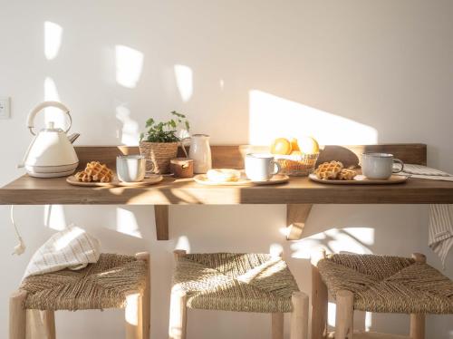 a table with plates of food and cups and stools at Luxury Apartment in Valencia City center in Valencia
