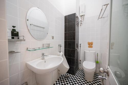 a bathroom with a sink and a toilet and a mirror at Fika Homestay Nguyên Căn 600m2 - Trung Tâm Quy Nhơn, Cách Biển 50m in Quy Nhon