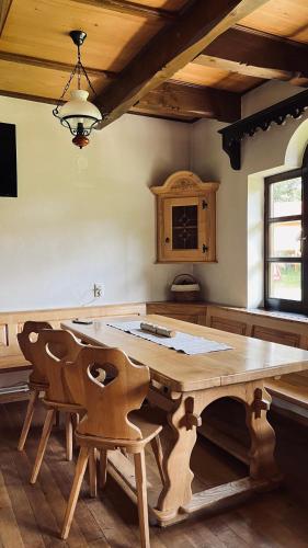 eine Küche mit einem großen Holztisch und Stühlen in der Unterkunft Casa de vacanta Aida in Zărneşti