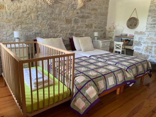 a bedroom with a bed and a stone wall at Coutillard in Parisot-Tarn-et-Garonne