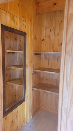 a cabin with wooden shelves and a mirror at Espacio BERNI in San Martín de los Andes