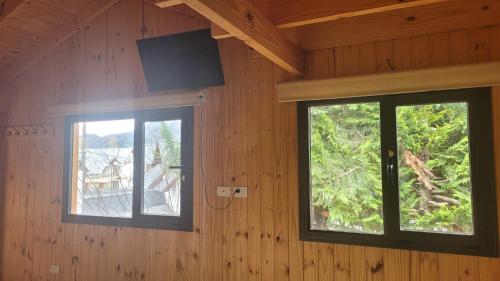 een kamer met twee ramen en een tv aan de muur bij Espacio BERNI in San Martín de los Andes