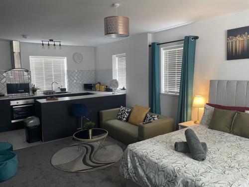 a living room with a bed and a kitchen at Entire Brand New Serviced Apartment in Moseley in Birmingham