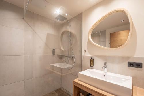 ein weißes Badezimmer mit einem Waschbecken und einem Spiegel in der Unterkunft Löckerwirt in Sankt Margarethen im Lungau