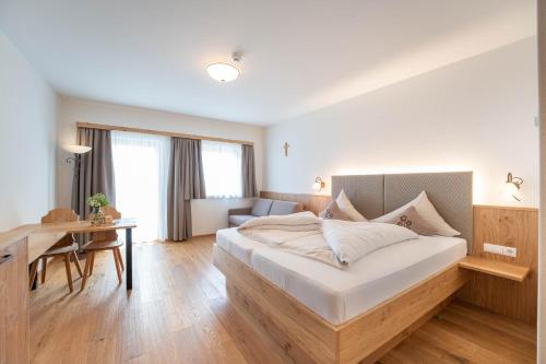 a bedroom with a bed and a desk and a couch at Löckerwirt in Sankt Margarethen im Lungau