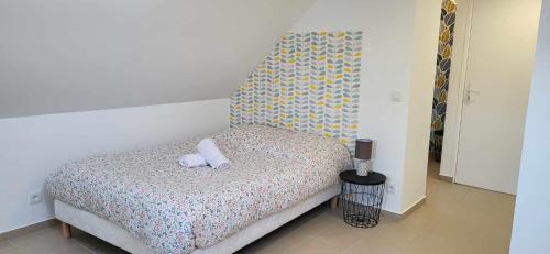 a bedroom with a bed with two pillows on it at Appart'Evry 2G in Évry-les-Châteaux