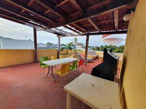 a patio with a table and chairs and a stove at Suites Los Arcos in Isla Mujeres