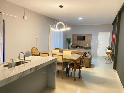 a kitchen and living room with a table and a dining room at Casa aconchegante 303 sul in Palmas