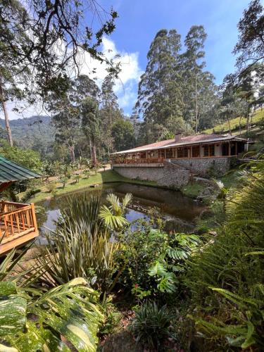 eine Brücke über einen Teich im Garten in der Unterkunft Cattaleya in Yumbo