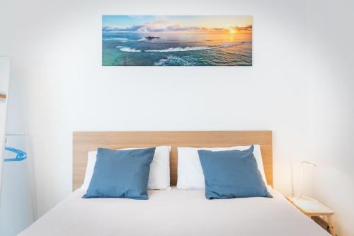 una camera da letto con un letto con cuscini blu e bianchi di Easy flat Vezia, indipendent entrance, free parking a Lugano