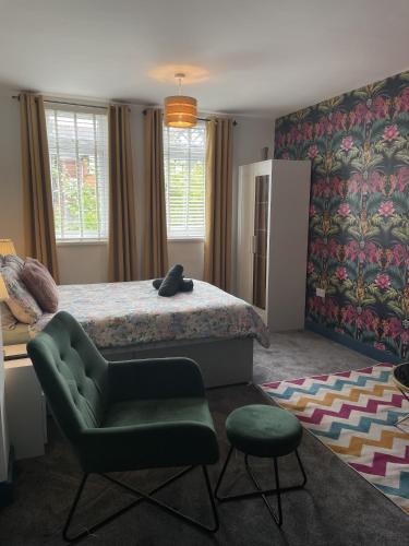 a bedroom with a bed and a green chair at Luxury studio apartment near Birmingham citycentre in Birmingham