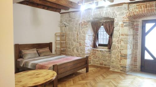 a bedroom with a bed and a stone wall at Regina di Dobrota in Kotor
