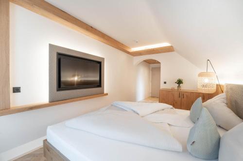 a bedroom with a bed and a tv on the wall at Löckerwirt in Sankt Margarethen im Lungau