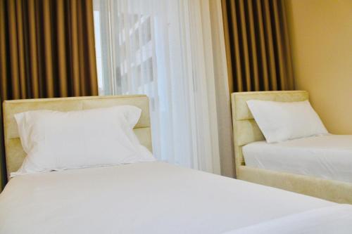a hotel room with two beds and a window at Holiday Apartment in Vlorë