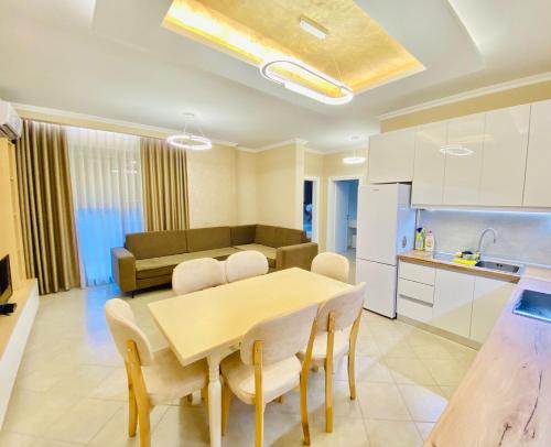 a kitchen and a dining room with a table and chairs at Holiday Apartment in Vlorë