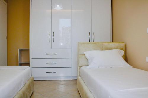 a bedroom with a white cabinet and a bed at Holiday Apartment in Vlorë
