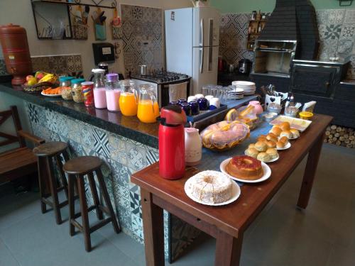 a table in a kitchen with breakfast foods and drinks at Hospedagem Caminho do Lago in Cunha
