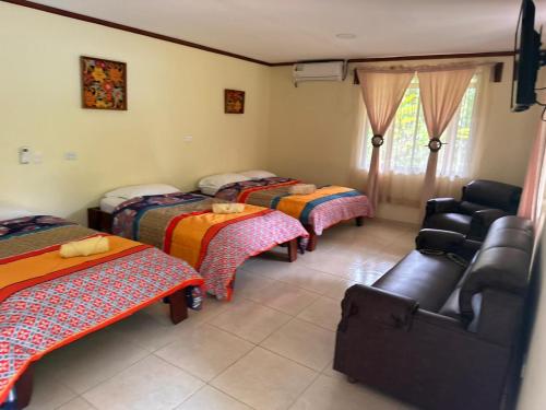 ein Zimmer mit 3 Betten und einem Stuhl darin in der Unterkunft RIVER SIDE LODGE in Horquetas